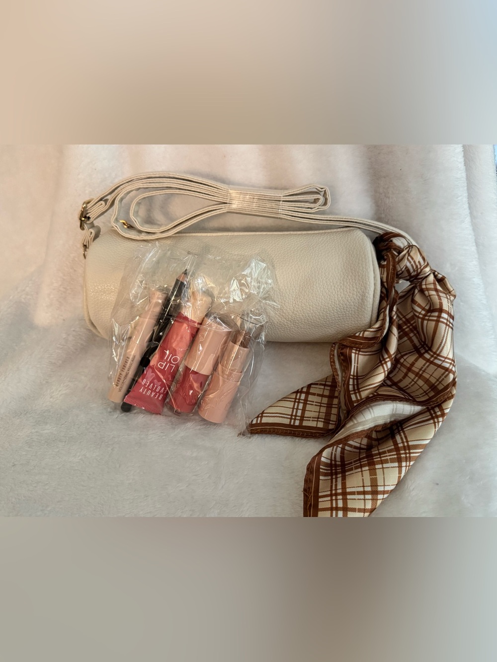 Cream Crossbody Barrel Bag with Matching Strap and Brown Plaid Scarf and Makeup